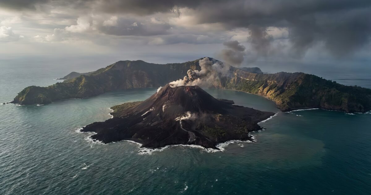 Anak krakatau volcano erupting from the ocean, spewing smoke and ash into the cloudy sky, displaying raw power and dynamic natural geological activity in indonesia